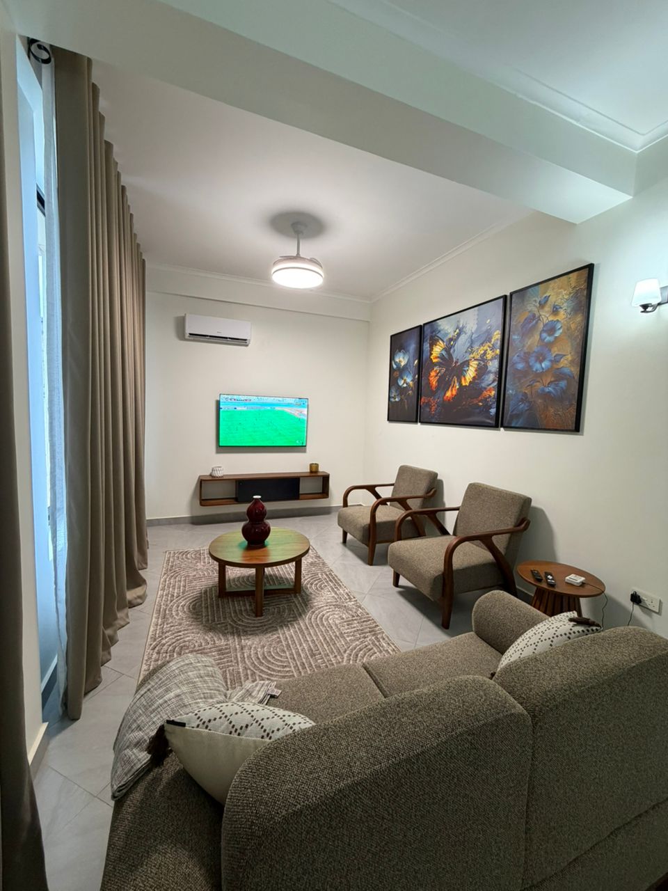 Double Hill Apartments spacious living room with modern furnishings, AC, and flat-screen TV